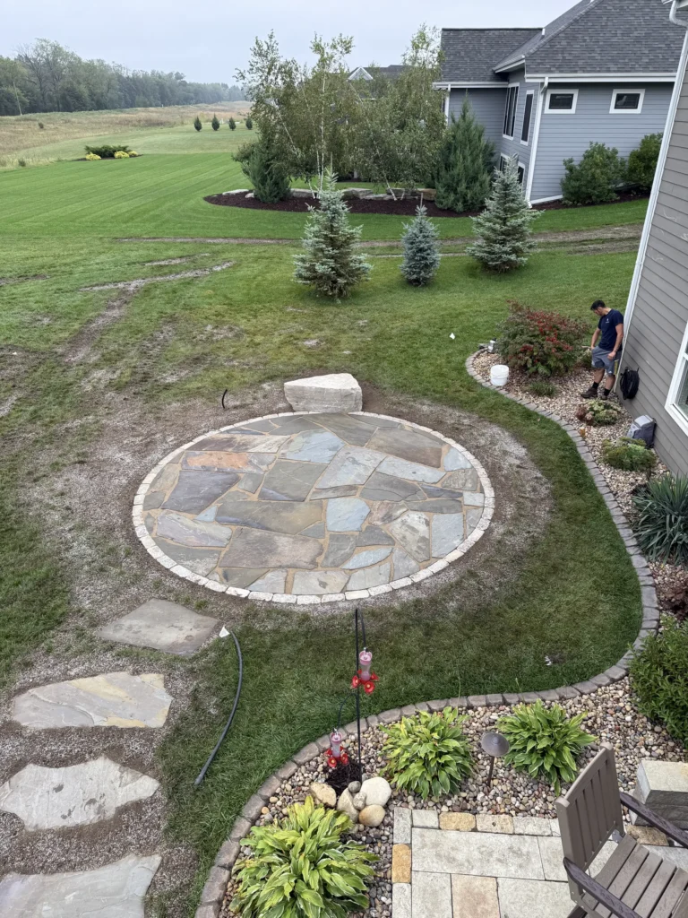 Image of back of home with outdoor deck overlooking manicured and professional landscaped yard in Waukesha